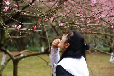 Woman standing against tree