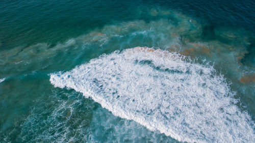 High angle view of waves splashing on sea