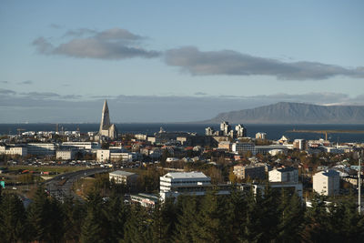 High angle view of townscape by sea against sky