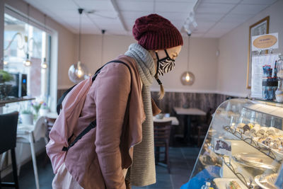 Side view of woman standing at store