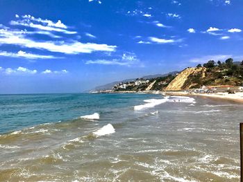 Scenic view of beach against cloudy sky