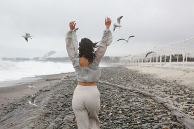 Full length of man standing on beach against sky