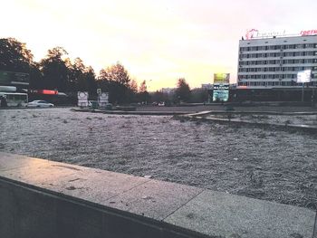 Cars on city against sky during sunset