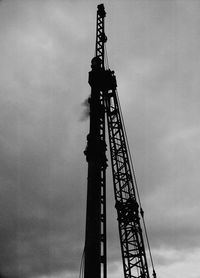 Low angle view of silhouette crane against sky