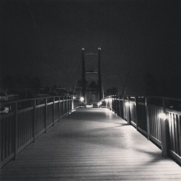 night, illuminated, the way forward, built structure, bridge - man made structure, connection, architecture, transportation, diminishing perspective, copy space, clear sky, lighting equipment, railing, water, long, street light, vanishing point, river, engineering, sky