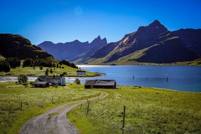 Scenic view of lake and mountains against clear blue sky