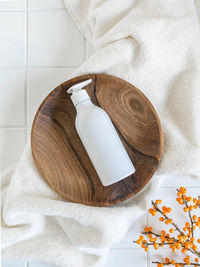 White plastic bottle with pump mock up, used for liquid soap, shampoo and lotion on wood tray 