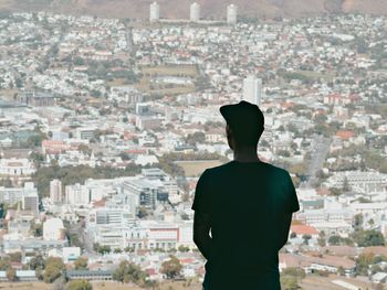 Rear view of man standing against cityscape