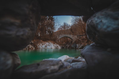 Rocks by lake against sky