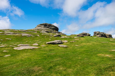 Rocks on field against sky