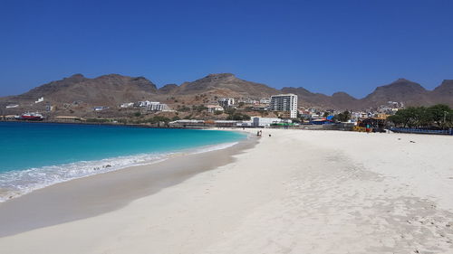 Scenic view of beach against clear blue sky