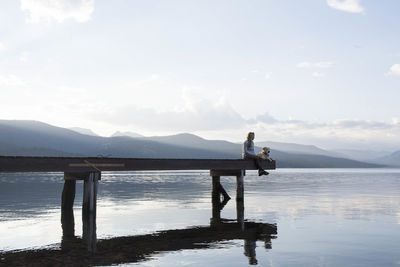 A woman and her dog enjoying an evening on the docks on hebgen lake.