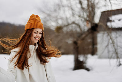 Portrait of young woman standing on snow