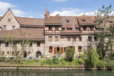 Arch bridge over river against buildings