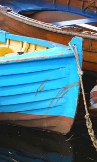 Close-up of blue ship moored on shore