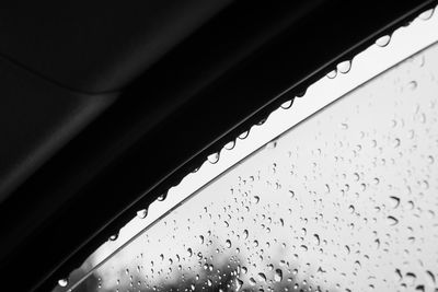 Low angle view of water drops on car window