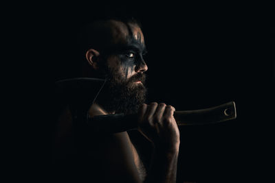 Portrait of young man against black background