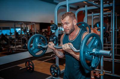 Muscular man exercising in gym