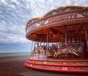 Ferris wheel at beach against sky