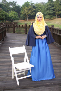 Portrait of beautiful woman in hijab standing on boardwalk