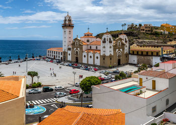 Buildings by sea against sky in city