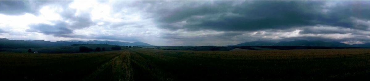 Panoramic view of agricultural field against sky