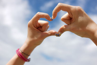 Cropped hands of woman making heart shape