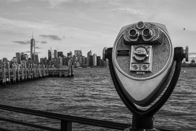 Coin-operated binoculars by east river against one world trade center