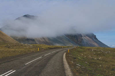 Road by mountains against sky