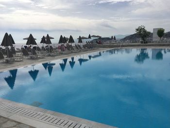 Swimming pool by sea against sky