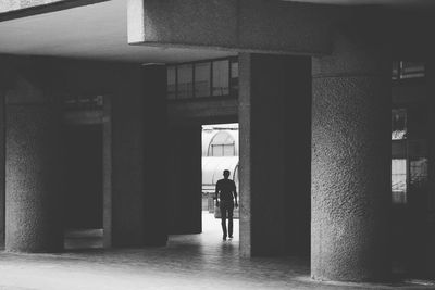Rear view of woman walking on wall