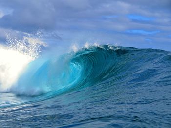 Aerial view of sea waves splashing against sky