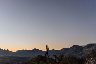 Man standing on mountain against clear sky