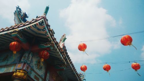 Low angle view of lanterns hanging against sky