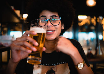 Portrait of young woman having beer in restaurant
