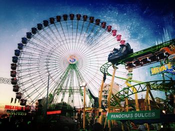 Low angle view of ferris wheel against sky