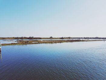 Scenic view of lake against clear blue sky