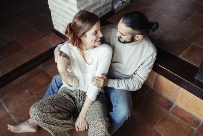 High angle view of woman sitting on floor at home