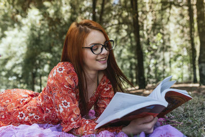 Portrait of smiling woman sitting in forest