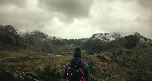 Rear view of man and mountains against sky
