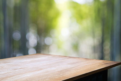 Close-up of empty chair on table against trees