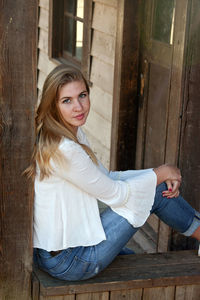 Portrait of young woman sitting in abandoned room