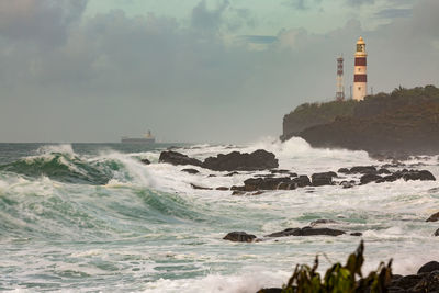 Lighthouse by sea against sky