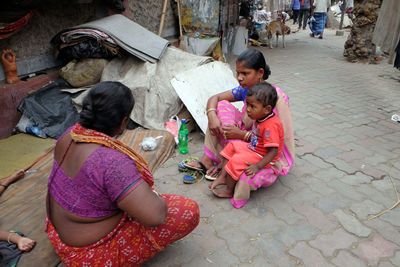 High angle view of girl sitting on street