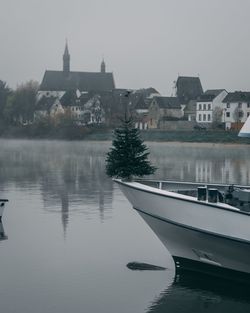 Buildings by lake against sky