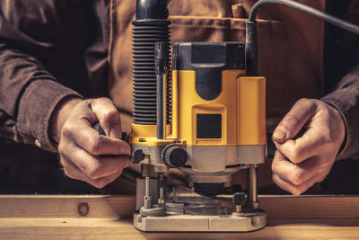 Midsection of worker repairing machinery