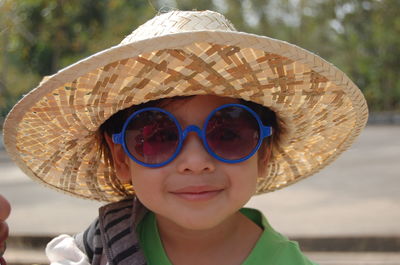 Portrait of boy wearing hat and sunglasses outdoors