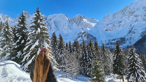 Rear view of woman on snowcapped mountains during winter