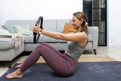 Young blonde wearing pilates ring at home