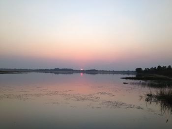 Scenic view of lake against sky at sunset